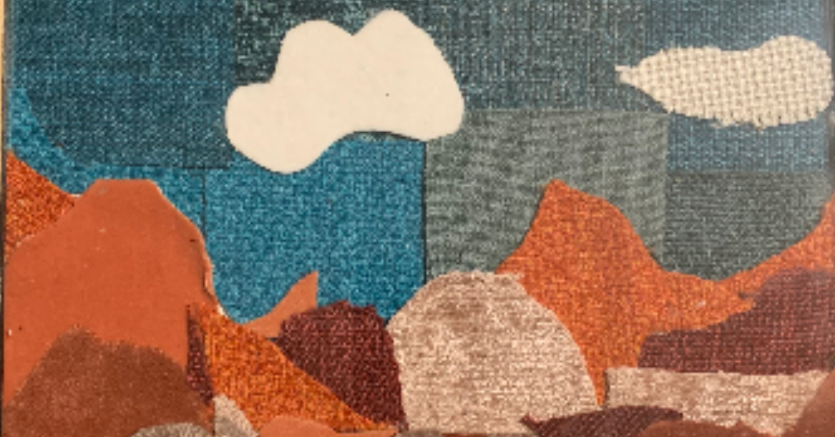 Fabric collage of brown and orange mountains, blue sky and clouds
